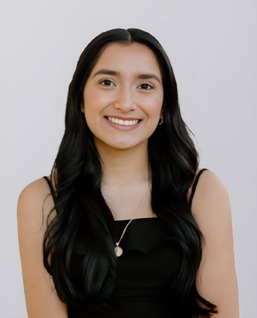 Professional headshot of a smiling woman with black hair in a black dress - Jasmine Martinez